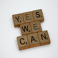 Blocos de madeira com os dizeres 'Yes we can', que traduzindo do inglês, significa 'Sim, nós podemos'.